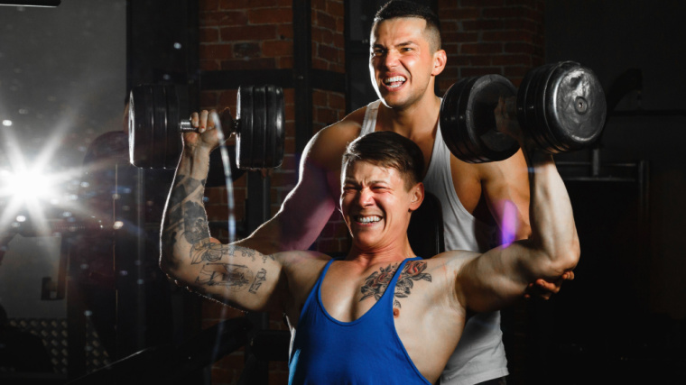 training partners in gym performing shoulder press