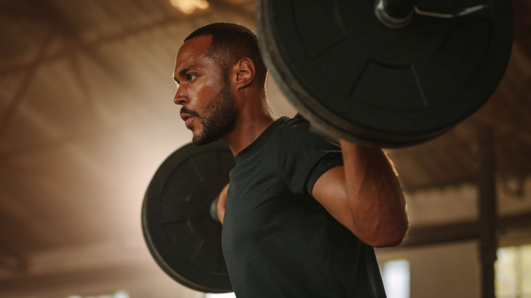 person holding bar during squat