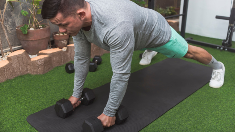 muscular person in outdoor gym in straight-arm plank