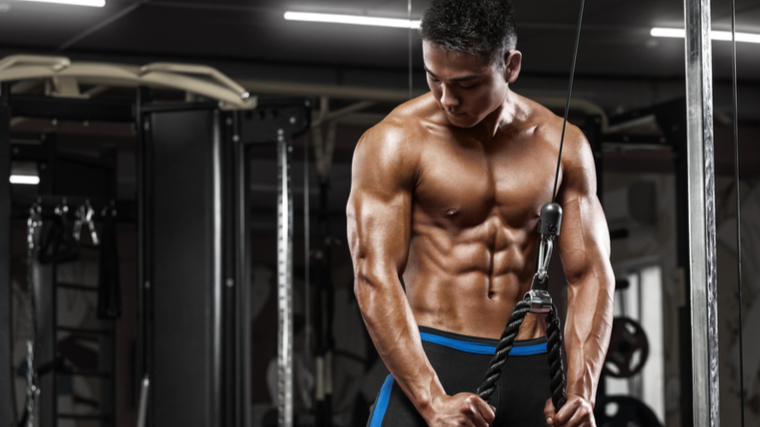 bodybuilder in gym performing rope pressdown triceps exercise