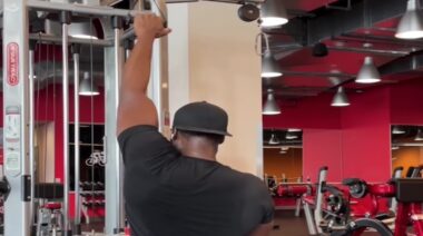 Coach Lee Boyce in gym doing back exercise on cable machine