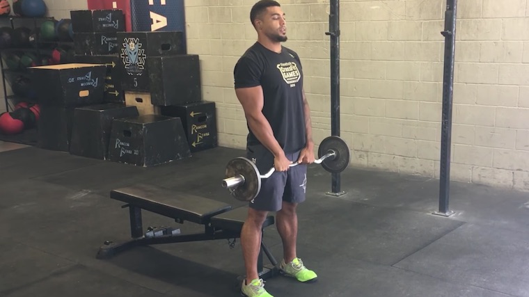 Muscular person in gym holding barbell